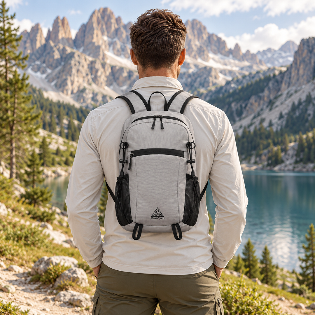 Hiker wearing a gray EasiCyco lightweight backpack beside a mountain lake